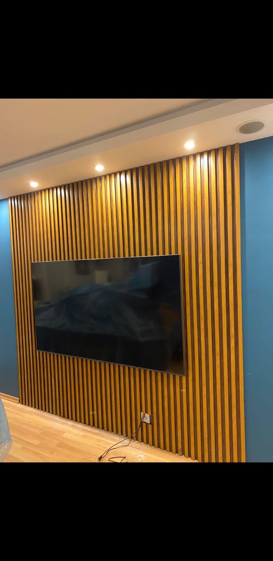 Dekoratif panel ve aydınlatma detaylarına sahip TV ünitesi uygulaması