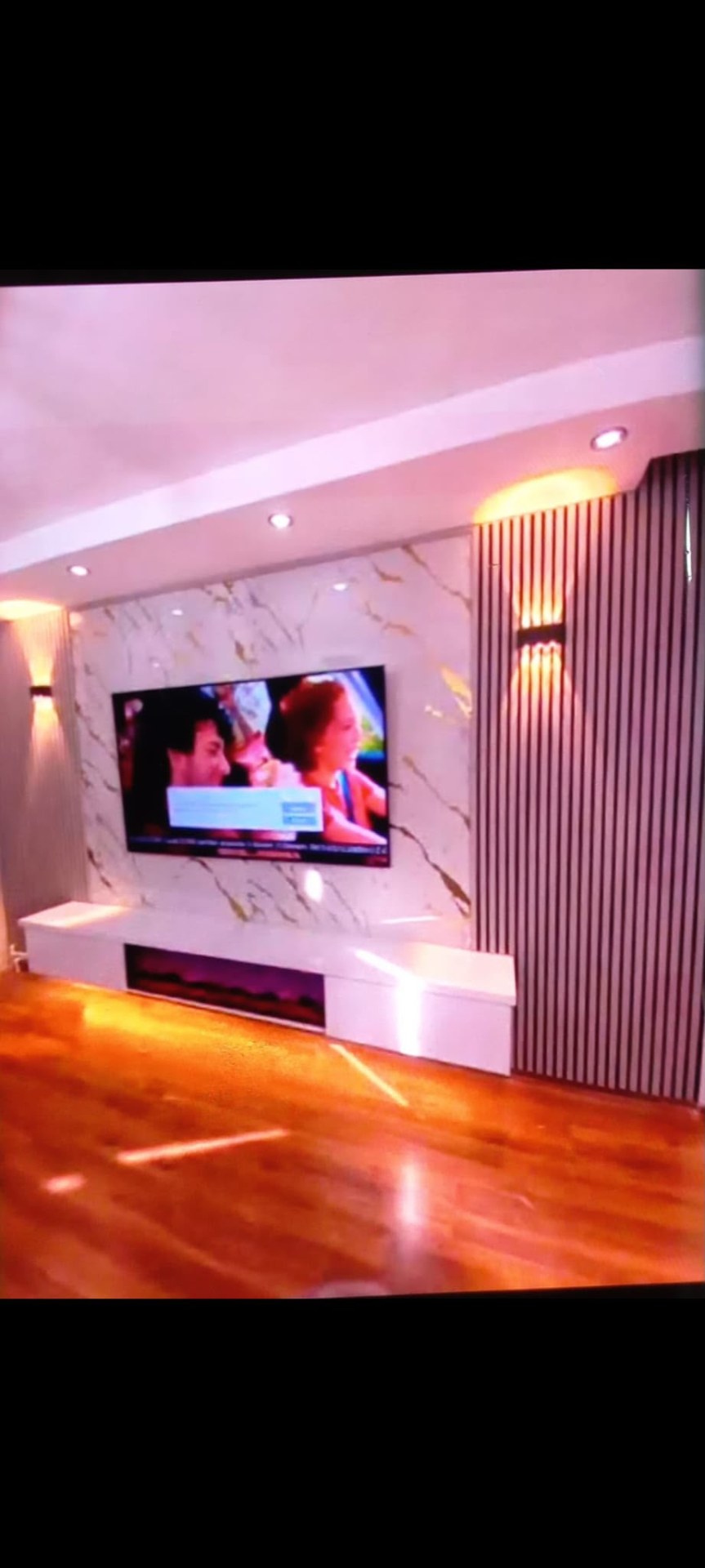 Dekoratif panel ve aydınlatma detaylarına sahip TV ünitesi uygulaması