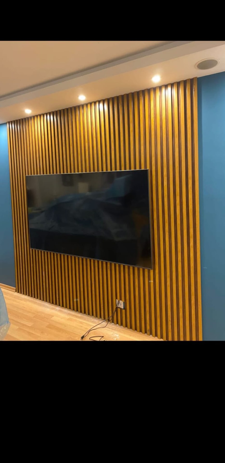 Dekoratif panel ve aydınlatma detaylarına sahip TV ünitesi uygulaması